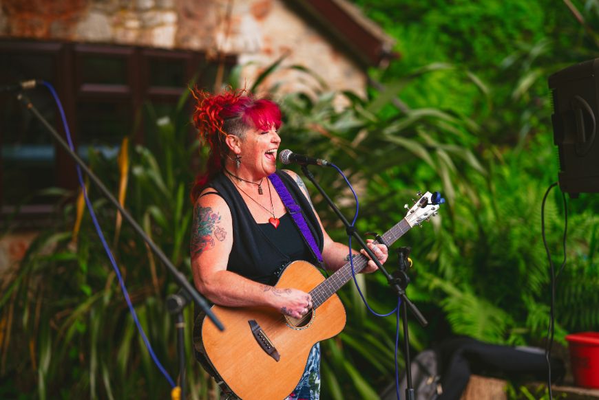 a lady singing and playing a guitar